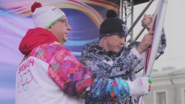 Saint Petersburg, Rusya - 27 Ekim 2013: bayrak yarışı Sochi Olimpiyat Meşalesi, Saint Petersburg. Işık tutan kimse Sahne Alanı'nda alev yakar. Çalışma başlatmak