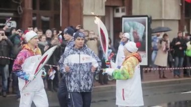 Saint Petersburg, Rusya - 27 Ekim 2013: St. Petersburg'da bayrak yarışı Sochi Olimpiyat meşalesi. Yaşlı kadın erkeğe alev geçer. Meşale taşıyıcıları