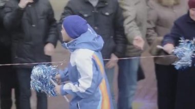 Saint Petersburg, Rusya - 27 Ekim 2013: Koşan çocuk gönüllü çocuklara ponpon vermek. St. Petersburg'da Soçi Olimpiyat meşalesi bayrak yarışı