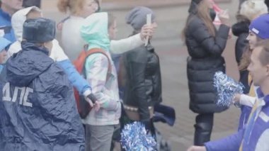 SAINT PETERSBURG, RUSSIA - OCTOBER 27, 2013: Boy volunteer give out pom pom people at road. Relay race of Sochi Olympic flame in Saint Petersburg