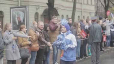 SAINT PETERSBURG, RUSSIA - OCTOBER 27, 2013: Boy volunteer run, give out pom pom people. Relay race of Sochi Olympic flame in Saint Petersburg