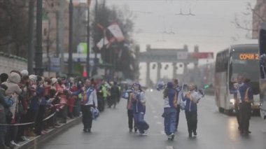 SAINT PETERSBURG, RUSSIA - OCTOBER 27, 2013: Walking volunteer give pom pom to people. Bus. Relay race of Sochi Olympic flame in Saint Petersburg