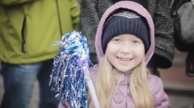 Saint Petersburg, Rusya - Ekim 27, 2013: Kamera mavi ponpon sallayarak küçük sarışın gülümseyen kız. Insanlar. Spor etkinliği