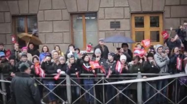 Saint Petersburg, Rusya - 27 Ekim 2013: Kalabalık sokak. İnsanlar kırmızı bayraklar sallıyor, elleri kamerada, gülümsüyor. Otobüsle giden kamera. Sonbahar