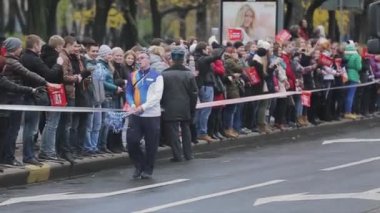SAINT PETERSBURG, RUSSIA - OCTOBER 27, 2013: Adult man give out pom pom people stay at road. Relay race Sochi Olympic flame in Saint Petersburg
