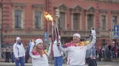 Saint Petersburg, Rusya - 27 Ekim 2013: St. Petersburg'da bayrak yarışı Sochi Olimpiyat meşalesi. İki meşale taşıyıcısı alev tutar, el sallar.