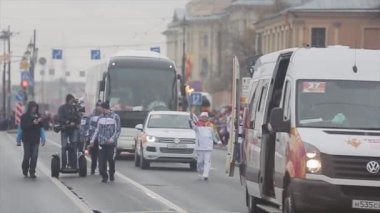 Saint Petersburg, Rusya - 27 Ekim 2013: Ekim ayında St. Petersburg'da bayrak yarışı Olimpiyat ateşi. Koşan meşale taşıyıcısı. Kortej. Kameraman