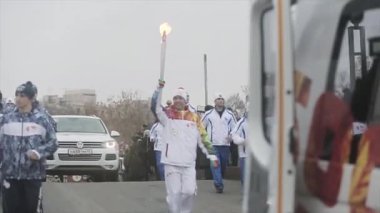 Saint Petersburg, Rusya - 27 Ekim 2013: Ekim ayında St. Petersburg'da bayrak yarışı Olimpiyat ateşi. Köprüde meşale taşıyıcısı çalıştırıyor. Insanlar