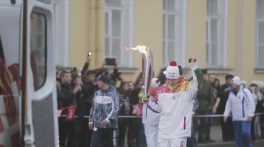 SAINT PETERSBURG, RUSSIA - OCTOBER 27, 2013: Relay race Olympic flame in Saint Petersburg in October. Running torchbearer welcome audience