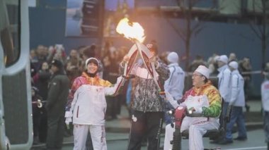SAINT PETERSBURG, RUSSIA - OCTOBER 27, 2013: Relay race Olympic flame in Saint Petersburg in October. Disabled torchbearer pass flame to woman