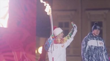 Saint Petersburg, Rusya - 27 Ekim 2013: St. Petersburg'da bayrak yarışı Olimpiyat ateşi. Egorova sahnede yanan meşaleile. Dalga el