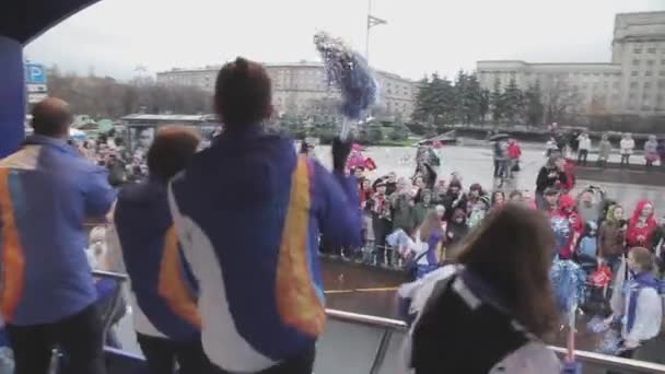 Petrohrad, Rusko - 27 října 2013: Mládež v autobusu vlna střapce na publikum. Štafetový závod olympijský oheň v Petrohradu. Kamera v autobuse — Stock video