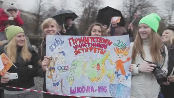 Αγία Πετρούπολη, Ρωσία - 27 Οκτωβρίου 2013: Νεαρά κορίτσια κρατήστε αφίσα με την Ολυμπιακή σημαία. Σκυταλοδρομία του Σότσι Ολυμπιακή φλόγα σε Αγία Πετρούπολη — Αρχείο Βίντεο