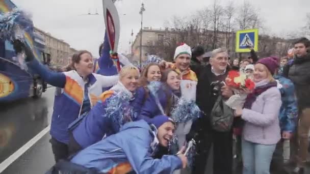 SAINT PETERSBURG, RUSSIA - OCTOBER 27, 2013: Relay race Sochi Olympic flame in Saint Petersburg. Girls in uniform, people photo with torchbearer — Stock video