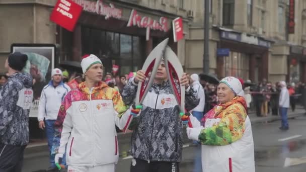 SAINT PETERSBURG, RÚSSIA - 27 de outubro de 2013: Corrida de revezamento Chama olímpica em São Petersburgo. Torchbearer aposentado passar chama para o jovem . — Vídeo de Stock