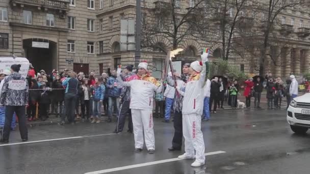 SAINT PETERSBURG, RUSSIA - OCTOBER 27, 2013: Relay race Sochi Olympic flame in Saint Petersburg. Torchbearers in uniform transfer fire. Wave hand — Αρχείο Βίντεο