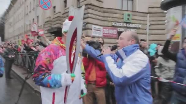 SAINT PETERSBURG, RUSSIA - OCTOBER 27, 2013: Walking boy with microphone come to torchbearer. Relay race Sochi Olympic flame in Saint Petersburg — Stock Video