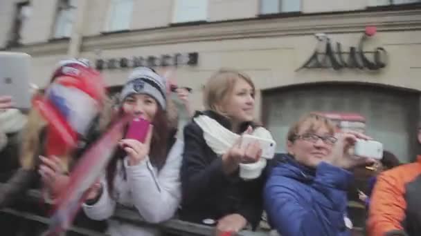 SAN PETERSBURG, RUSIA - 27 DE OCTUBRE DE 2013: Muchas jóvenes ondean banderas rojas, las manos en la cámara, sonríen. Dispara en cámara. Evento — Vídeo de stock