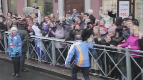 SAINT PETERSBURG, RUSSIA - OCTOBER 27, 2013: Volunteer give five crowd. Relay race Sochi Olympic flame in Saint Petersburg. Torchbearer Alyabyev — Stockvideo