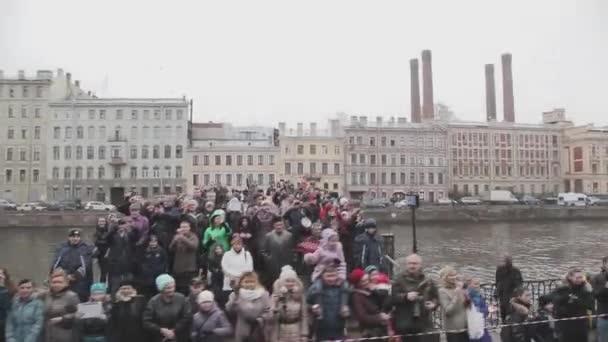 Petrohrad, Rusko-27. října 2013: mnozí lidé na můstku, červené vlajky, ruce v kameře, úsměv. Střílejte na kameru. Událost — Stock video