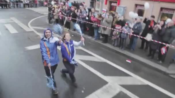 SAN PETERSBURG, RUSIA - 27 DE OCTUBRE DE 2013: Dos voluntarios, agitando pom pom, baile divertido. Carrera de relevos de la llama olímpica de Sochi en San Petersburgo . — Vídeo de stock