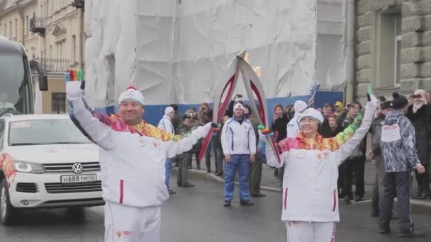 Sint-Petersburg, Rusland-27 oktober 2013: estafette race Sochi Olympische fakkel in Sint-Petersburg. Torchbearers passeren vlam. Golf handen. Oktober — Stockvideo