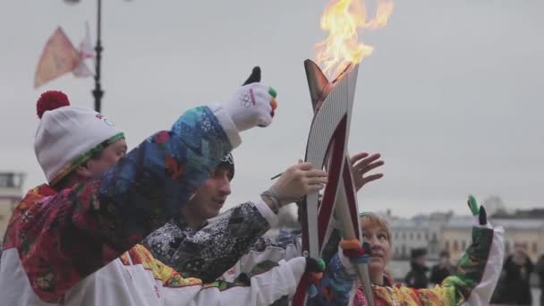 Sint-Petersburg, Rusland-27 oktober 2013: estafette race Sochi Olympische fakkel in Sint-Petersburg. Moment van torchbearers passeren vlam. Golf handen. — Stockvideo