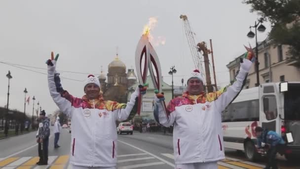 Sint-Petersburg, Rusland-27 oktober 2013: estafette race Sochi Olympische fakkel in Sint-Petersburg. Torchbearers passeren vlam. Poseren op camera — Stockvideo
