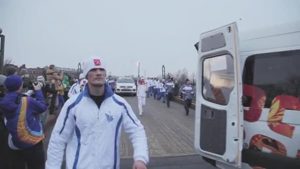 SAN PETERSBURG, RUSIA - 27 DE OCTUBRE DE 2013: Carrera de relevos Sochi Antorcha olímpica en San Petersburgo. Portadores de antorchas con llama. Cortejo en el puente — Vídeo de stock