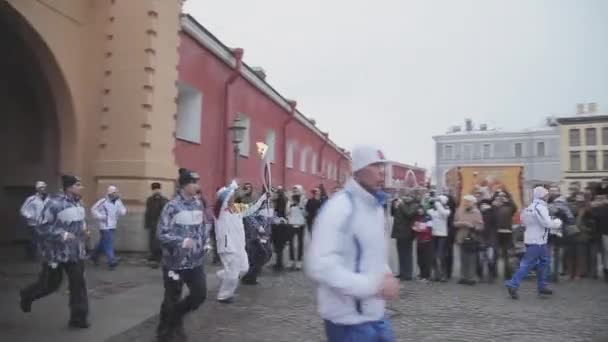 SAINT PETERSBURG, RÚSSIA - OUTUBRO 27, 2013: Corrida de revezamento Sochi tocha olímpica em São Petersburgo, Peter e Paul Fortaleza. Torchbearer com chama — Vídeo de Stock