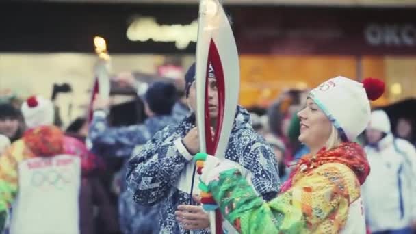 SAINT PETERSBURG, RUSSIA - OCTOBER 27, 2013: Relay race Sochi Olympic torch in Saint Petersburg. Female torchbearer start run with flame. Smile — Stockvideo