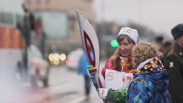 САЙНТ-ПЕТЕРБУРГ, РОССИЯ - 27 октября 2013 года: Эстафета Олимпийского огня в Санкт-Петербурге. Женщина-факелоносец готовится к бегу — стоковое видео