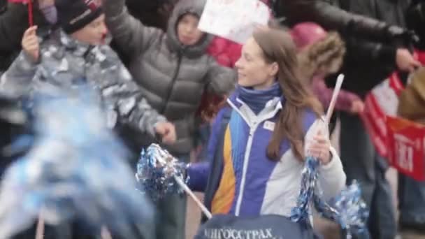 SAINT PETERSBURG, RUSSIA - OCTOBER 27, 2013: Volunteers give pom pom to children. Relay race of Sochi Olympic flame in Saint Petersburg. — Stock Video