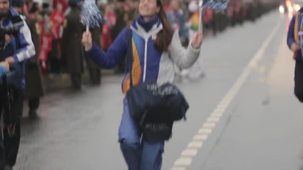 СЕНТ-ПЕТЕРБУРГ, РОССИЯ - 27 ОКТЯБРЯ 2013: Молодые волонтеры машут помпоном, ходят по дороге. Эстафета Олимпийского огня в Сочи в Санкт-Петербурге — стоковое видео