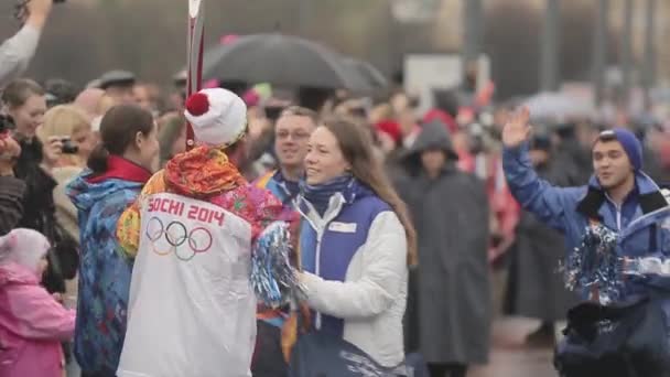 SAINT PETERSBURG, RÚSSIA - OUTUBRO 27, 2013: Voluntários caminham, abraçam o portador de tochas na estrada. Corrida de revezamento de Sochi chama olímpica em São Petersburgo — Vídeo de Stock