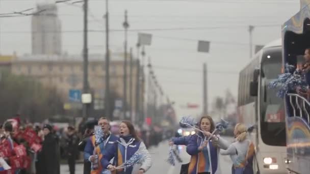 SAN PETERSBURG, RUSIA - 27 DE OCTUBRE DE 2013: Jóvenes voluntarios sacuden pom pom, caminan por la carretera. Carrera de relevos de la llama olímpica de Sochi en San Petersburgo — Vídeo de stock
