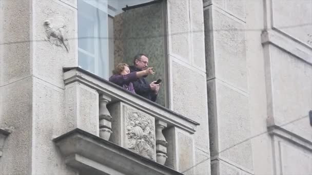 SAINT PETERSBURG, RUSSIE - 27 OCTOBRE 2013 : Homme et femme adultes agitent les mains depuis le balcon. Le bonheur. L'architecture. La maison. Bâtiment — Video