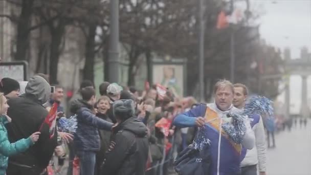 SAN PETERSBURG, RUSIA - 27 DE OCTUBRE DE 2013: Hombre anciano voluntario reparte pom pom people. Carrera de relevos de la llama olímpica de Sochi en San Petersburgo — Vídeo de stock