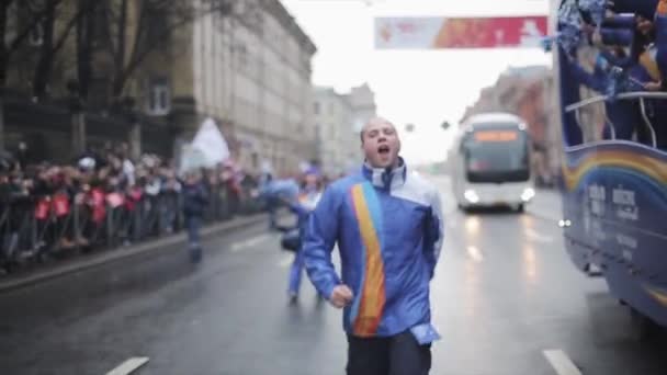 SAN PETERSBURG, RUSIA - 27 DE OCTUBRE DE 2013: Niño feliz corriendo por la carretera. Voluntariado cortejo. Carrera de relevos de la llama olímpica de Sochi en San Petersburgo — Vídeo de stock