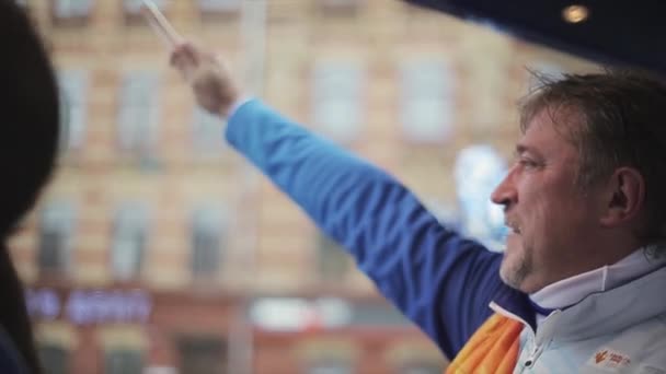 Saint petersburg, russland - 27. oktober 2013: mann winkt pom pom aus bus. Ehrenamtliche Cortege. Staffellauf der olympischen Flamme von Sotschi in St. Petersburg — Stockvideo