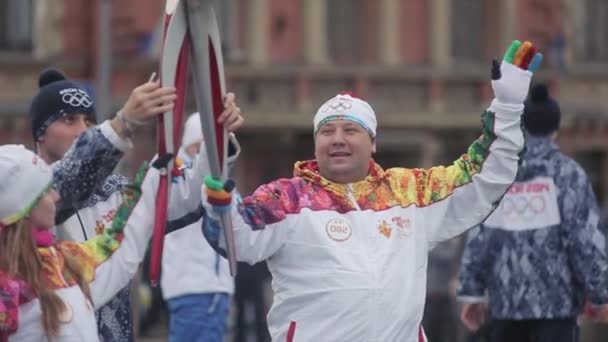 SAINT PETERSBURG, RUSSIA - OCTOBER 27, 2013: Relay race Sochi Olympic torch in Saint Petersburg. Two torchbearers hold flame. Passing torch — Stock Video