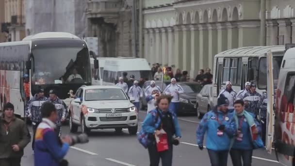 SAN PETERSBURG, RUSIA - 27 DE OCTUBRE DE 2013: Carrera de relevos Llama olímpica en San Petersburgo en octubre. Mano portantorchas corriendo. Cortejo. — Vídeos de Stock