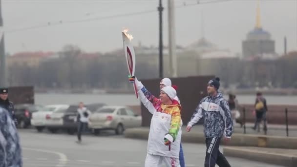 Saint Petersburg, Rusya - 27 Ekim 2013: Ekim ayında St. Petersburg'da bayrak yarışı Olimpiyat ateşi. Yürüyen kadın meşale taşıyıcısı. Muhafız. — Stok video
