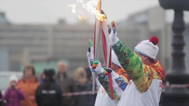 Αγία Πετρούπολη, Ρωσία-27 Οκτωβρίου, 2013: ιπποδρομία Σότσι Ολυμπιακή φλόγα στην Αγία Πετρούπολη. Δύο λαμπαδηφόρες με ομοιόμορφη Κρατήστε το χέρι φλόγα κύμα — Αρχείο Βίντεο