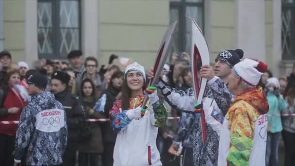 SAINT PETERSBURG, RUSSIA - OCTOBER 27, 2013: Relay race Olympic flame in Saint Petersburg in October. Aged torchbearer pass flame to woman — 비디오