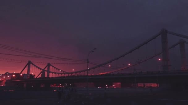 Vista en el dramático cielo nocturno rojo y negro tormenta de truenos. Iluminación flash. Puente. Tiempo tormentoso . — Vídeo de stock