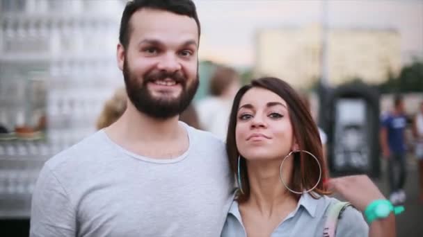 Mujer linda joven y hombre barbudo sonriendo en la cámara. Pareja de citas. Noche de verano. Retrato — Vídeos de Stock