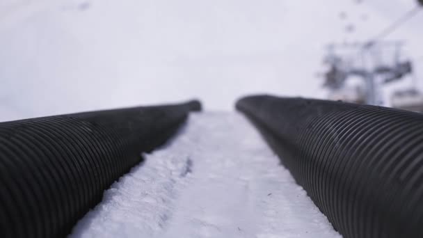 Lyžařské středisko. Pohled na dlouhý černý odrazný můstek. Snowboardisty a Lyžníci. Slunečný den. — Stock video