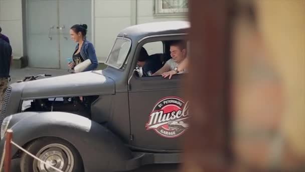 MOSCA, RUSSIA - 27 LUGLIO 2015: Due giovani in camicia escono dal vecchio pick-up, sorridono. Giornata estiva di sole. Avventura. Gente. Riunione — Video Stock