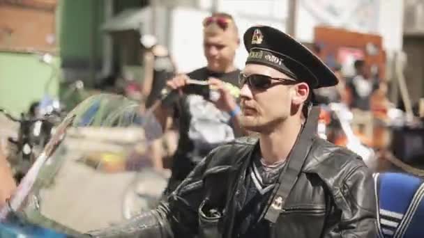 MOSCÚ, RUSIA - 27 DE JULIO DE 2015: Motero adulto en gafas de sol, chaqueta de cuero, paseo en sombrero náutico en motocicleta pintada. Día soleado de verano — Vídeos de Stock